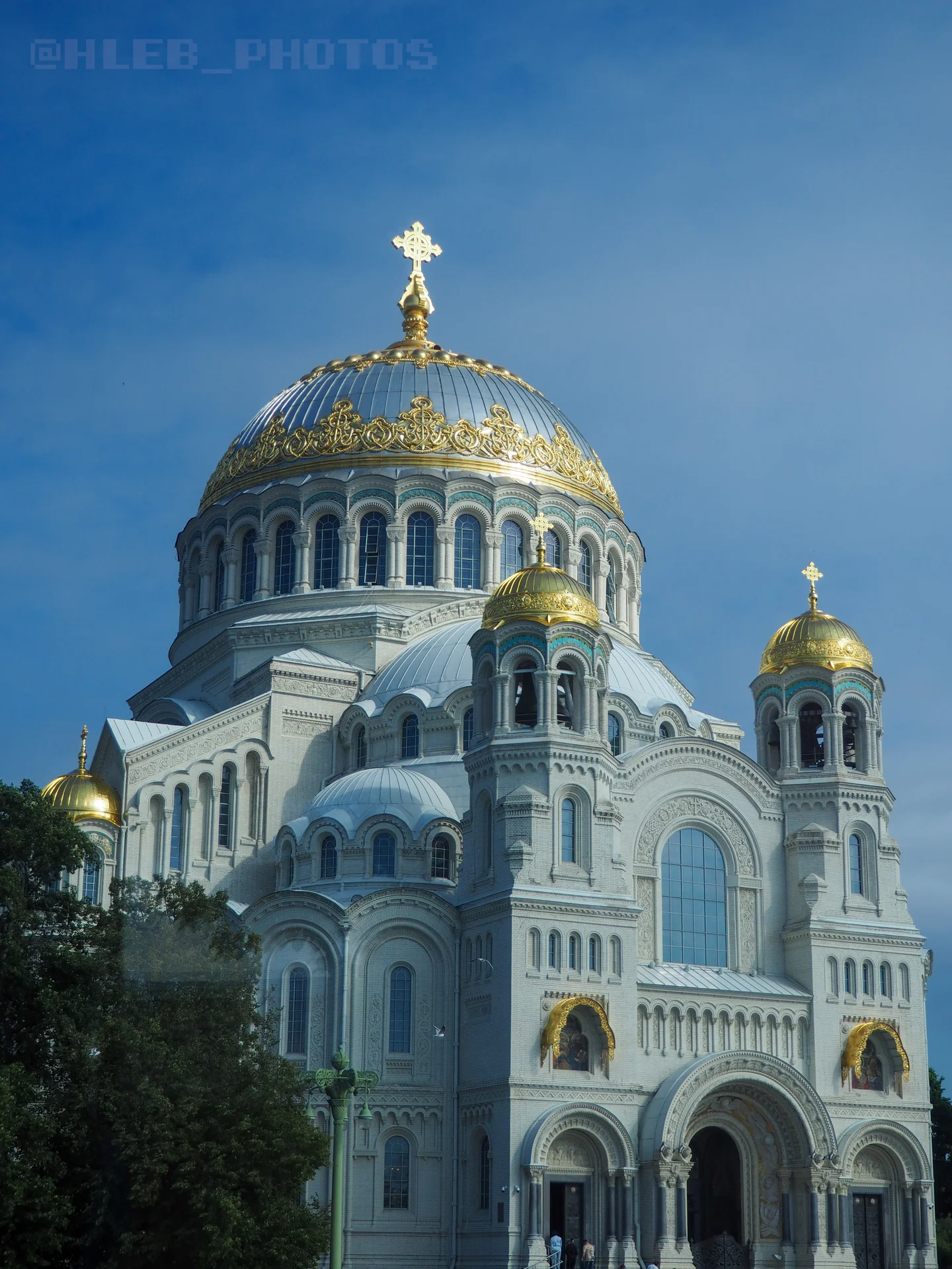 Величественный белый собор с массивным центральным куполом, золотым орнаментом и крестом.