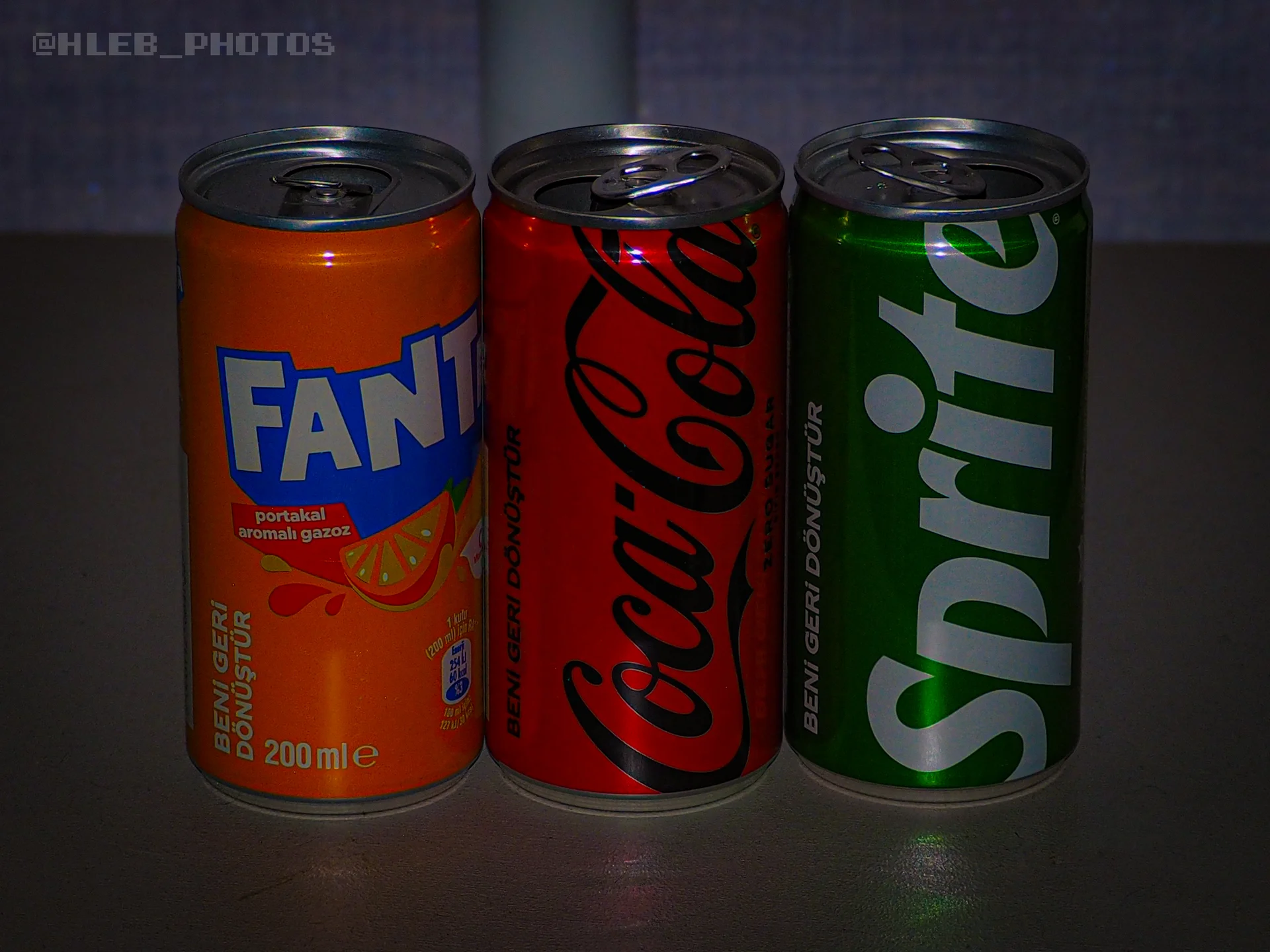 Ряд из трех жестяных банок: Fanta, Coca-Cola и Sprite.