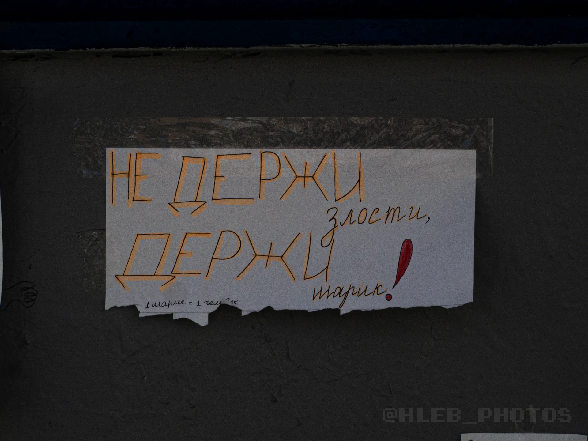 Объявление на серой стене с надписью: «НЕ ДЕРЖИ злости, ДЕРЖИ шарик!».