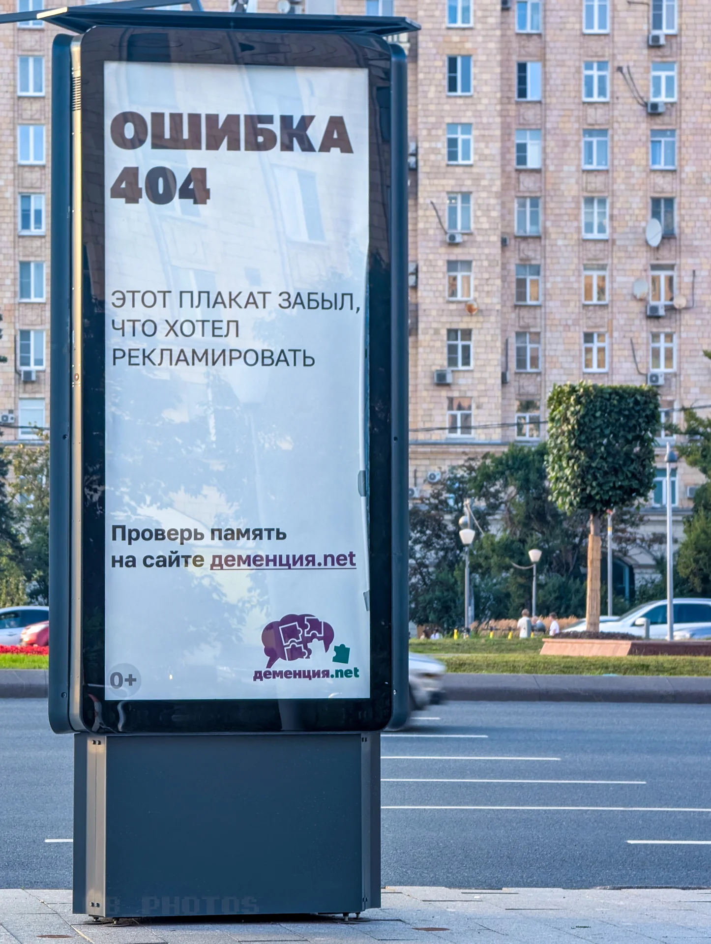 Уличный рекламный лайтбокс с надписью «Ошибка 404» и текстом социальной рекламы на фоне городской улицы.